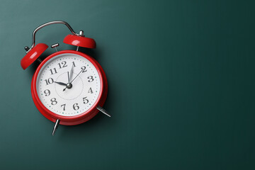 Alarm clock on green chalkboard, top view with space for text. School time