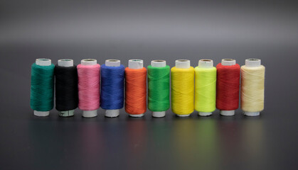 Group of whole haberdashery item colorful thread spools isolated on black background