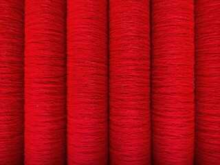 Red threads. Yarn. Bobbins with yarn. Fabric. Sewing threads. Skein of thread. Texture of red thread in spoolls.