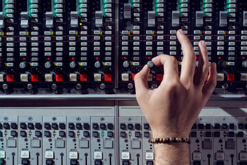 hands of a person adjusting studio mixer volume 