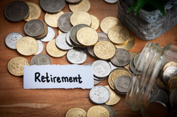 Retirement text on torn paper with coins and wooden table background.