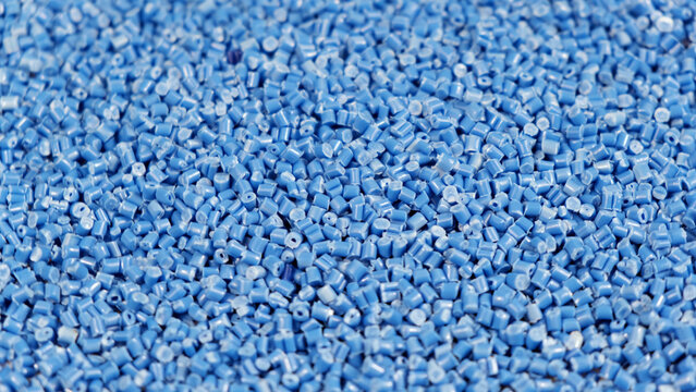 Secondary Granule Made Of Polypropylene, Blue Plastic Pellets Crumbles To The Table. Plastic Raw Materials In Granules For Industry. Polymer Resin. Raw Plastic Recycling Concept