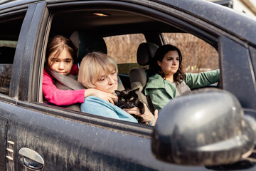 Family with child, senior woman and cat driving in car to Europe forced to flee from Ukraine...