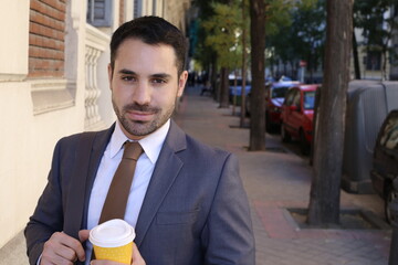 Good looking businessman holding coffee cup to go
