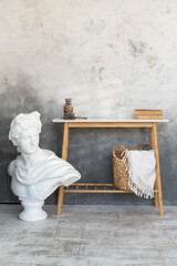 Statue of Apollo and a white table with books