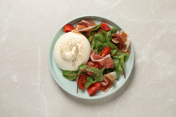 Delicious burrata salad on light grey marble table, top view