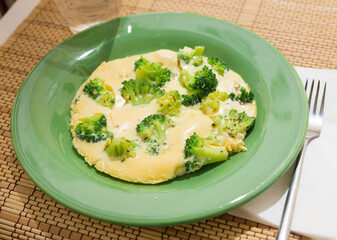 wholesome breakfast. omelet with broccoli on green plate
