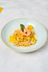 Italian pasta fettuccine in a creamy sauce with shrimp on a plate