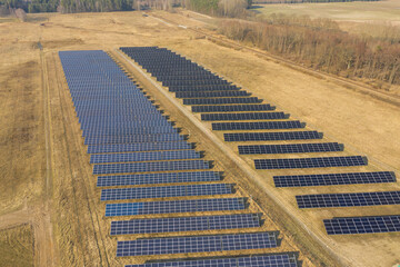 Farma paneli solarnych na równinie pokrytej suchą żółtą trawą. - 494682495