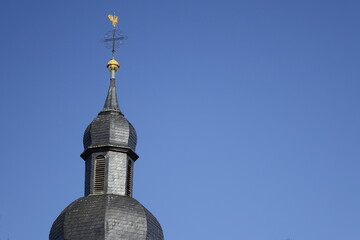 Top of protestant church Unionskirche (left), black slate shingles, golden weather cock, clear blue sky, use: copy space, texture, background, concept: religion (horizontal), Kaiserslautern, Germany