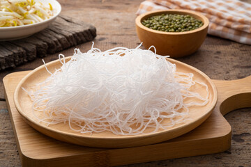 Fresh Glass Noodle (Transparent bean vermicelli) on wooden plate with Green beans on spoon