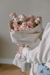 Beautiful bouquet of fresh flowers in female hands. The concept of a festive mood in women