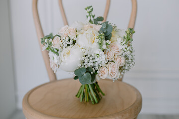 Wedding bouquet of flowers for the bride in female hands. White peonies