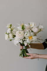 Beautiful bouquet of fresh flowers in female hands. The concept of a festive mood in women