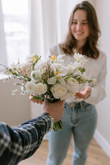 Male hand giving a bouquet of flowers to a young woman