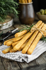 Front view of traditional italian appetizer grissini with rosemary salt and green olives