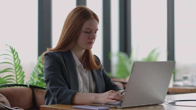 financial specialist of big modern company is working in office, young pretty lady is sending email by laptop