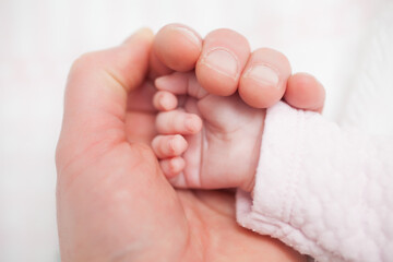Father holding hand of newborn child