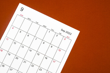 September 2022 calendar sheet on red background.