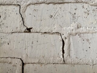 Fototapeta premium an old white brick wall with a crack