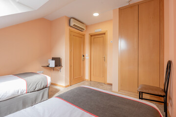 Fototapeta na wymiar bedroom with double beds in a hotel room with fitted wardrobes