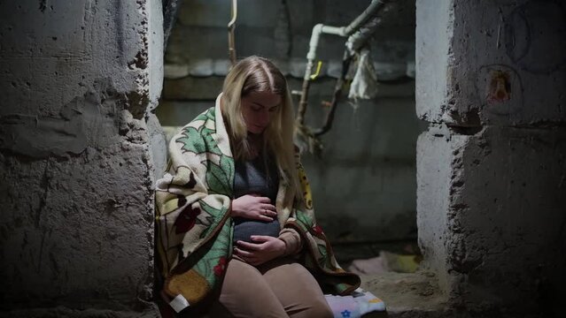 War in Ukraine. A Ukrainian pregnant woman hides in a bomb shelter while resisting a Russian invasion.
