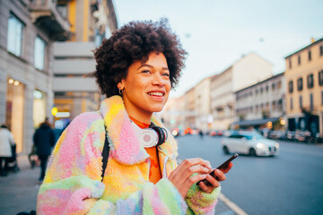 Young mixed race woman outdoor smiling having fun using smartphone