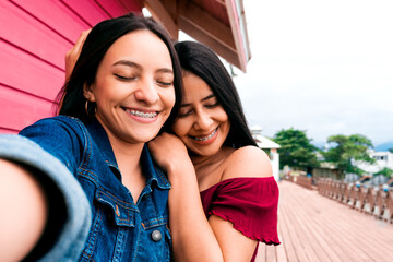 Happy women friends with braces smiling taking a photo