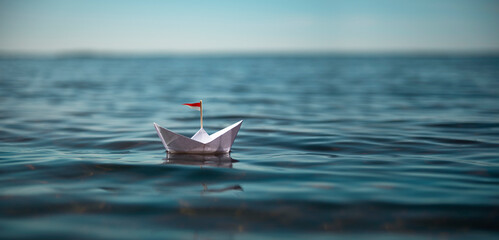 Kleines Papierschiff auf sonnigem See