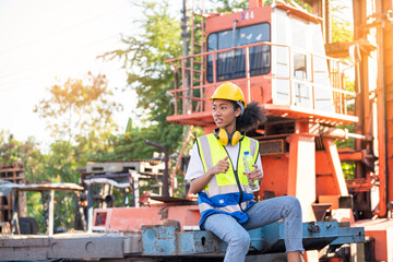 Divergent A African american woman foreman or worker wearing Cross Eye safety is drinking a bottle...