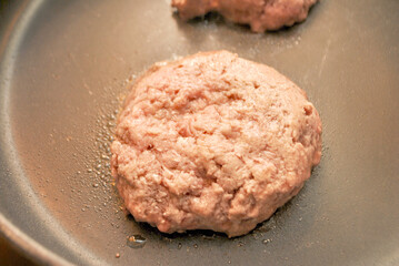 Frying Beef Burgers in a Black Pan	