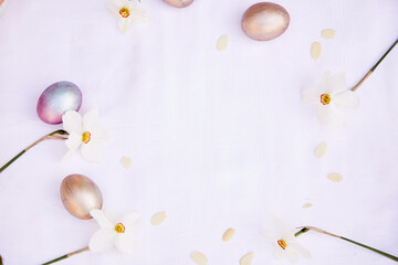 Easter trendy background. Purple vintage and orange multicolored eggs and narcissus flowers. Top view, copy space