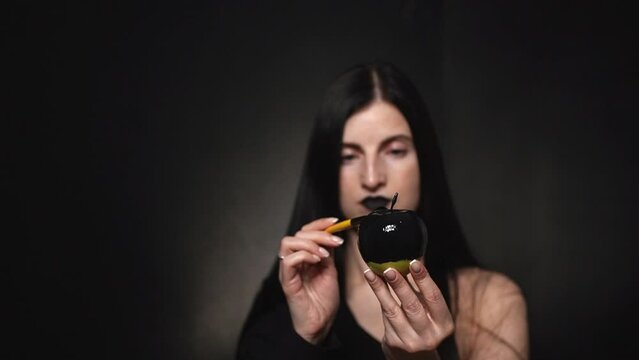 girl looking at a black apple