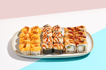 Set of hot maki sushi on ceramic dishware. Baked sushi set in minimal style. Tempura rolls in modern concept. Japanese menu in modern style.