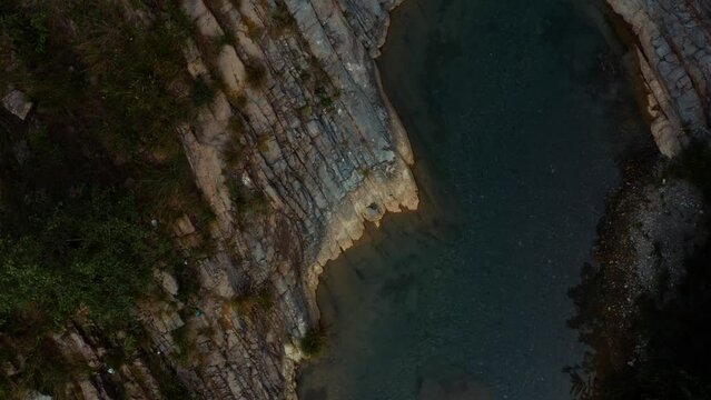 Close aerial view of a river in between the mountains at Noori waterfall,Pakistan