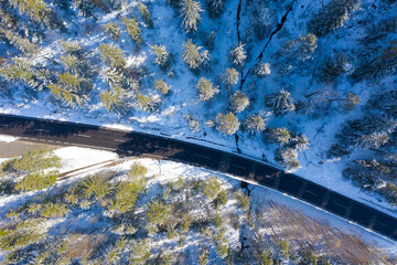 Drone photography of a winding mountain road in Europe near the austrian village Bad Goisern. winter mountains landscape. Snow-covered trees and mountain slopes. Austria, Steiermark, Europe