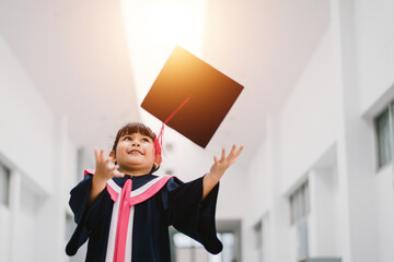 Cute Asian graduated schoolgirl with graduation gown in school campus