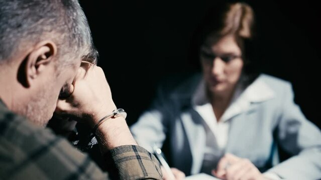 Arrested man refusing to testify or sign a confession, interrogation scene