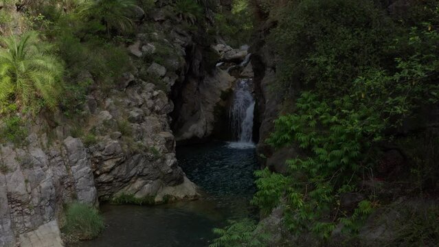 Aerial view of a water flowing into the river in between the mountains 