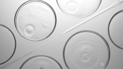 Grayscale top view macro shot of transparent drops are falling into transparent liquid in multiple petri dishes lying around droppers | Abstract skin care cosmetics formulating concept