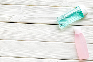 facial tonic and lotion for face care on white wooden background top view mock up