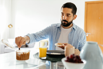 Obraz na płótnie Canvas Man sitting at the table eating vegan breakfast