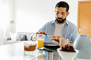 Fototapeta na wymiar Man sitting at the table eating vegan breakfast