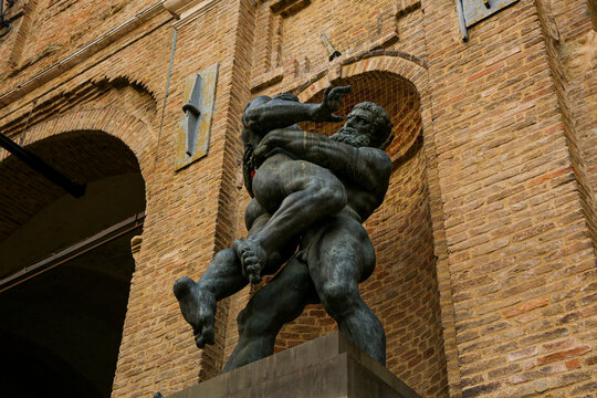 The sculpture of wrestling Hercules and Antaeus next to the wall of the Parma Town Hall on the top of the fountain, Italy.
