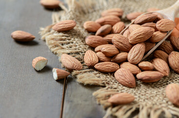 Almonds nut in wood spoon on wood background.