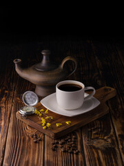 cup of black coffee with coffee beans on wooden background.