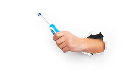 Male hand holding modern electric toothbrush on white background. Banner, copy space. Controlled oral hygiene tool, ad space.