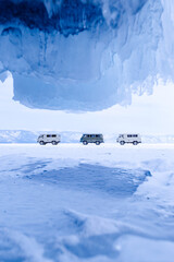 Blue ice cave grotto lake Baikal Russia and car for tourist travel. Frozen icicles, beautiful winter landscape