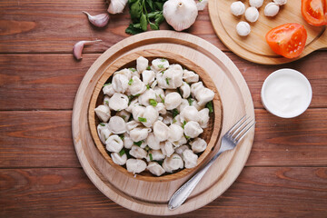 Ready-made dumplings on a white plate with onions and spices