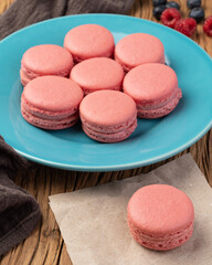 Berry macarons on a plate over wooden table